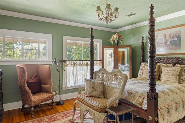 bedroom with a notable chandelier, wood-type flooring, and crown molding