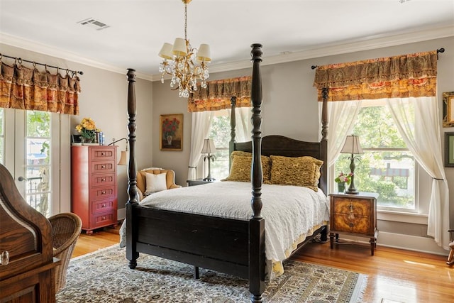 bedroom with hardwood / wood-style flooring, a notable chandelier, and crown molding