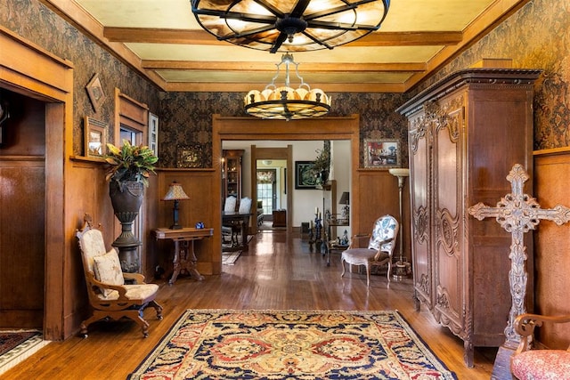 foyer entrance with beamed ceiling, dark wood-type flooring, and a notable chandelier