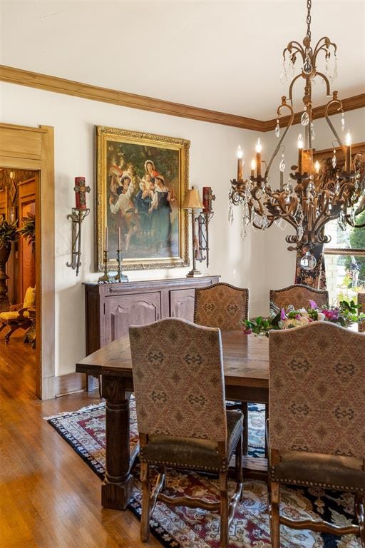 dining space with hardwood / wood-style floors and crown molding