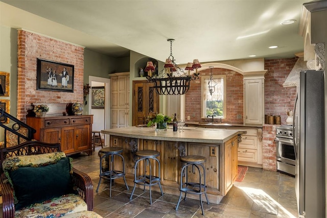 kitchen with a breakfast bar, stainless steel appliances, sink, a center island with sink, and an inviting chandelier