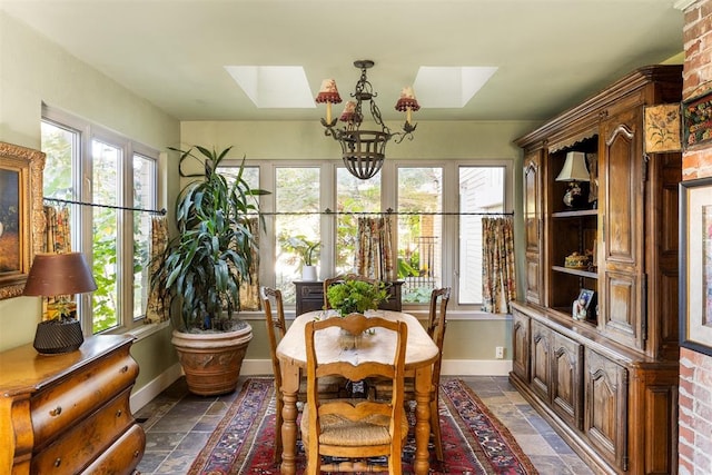 dining space with a chandelier, a skylight, and plenty of natural light