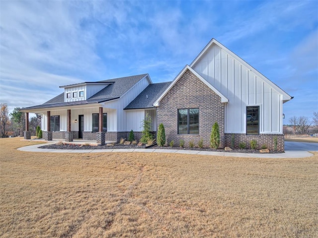 modern farmhouse with covered porch and a front lawn