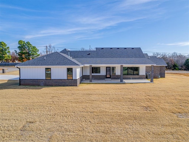 rear view of property with a patio area and a yard