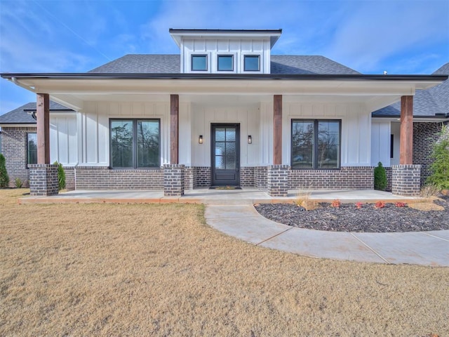 view of front of property featuring covered porch and a front lawn