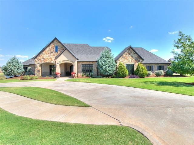 1205 Cobblestone Ln, Kingfisher, OK 73750 - view of front facade featuring stone siding, a front lawn, and curved driveway