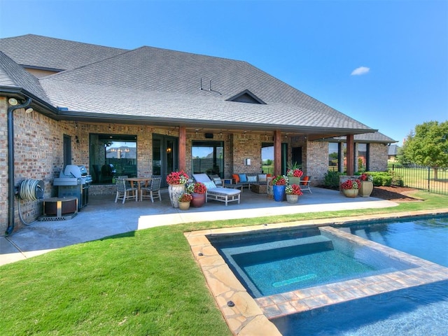 back of property with a swimming pool with hot tub, a patio area, and an outdoor hangout area