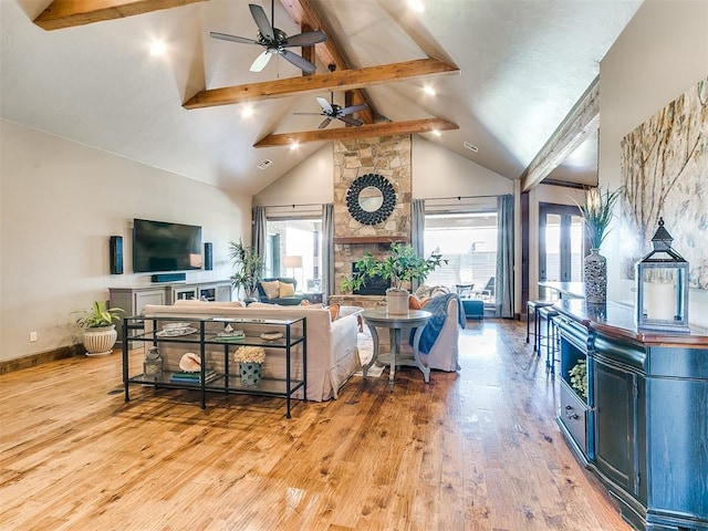 living room with beam ceiling, a fireplace, high vaulted ceiling, and light wood-type flooring