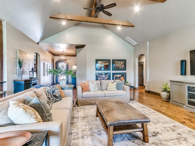 living room with beamed ceiling, light wood-type flooring, high vaulted ceiling, and ceiling fan