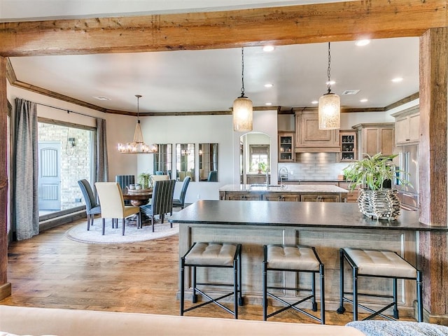 kitchen with plenty of natural light, tasteful backsplash, light brown cabinetry, and light hardwood / wood-style flooring