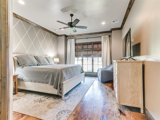 bedroom featuring ceiling fan, wood-type flooring, and ornamental molding