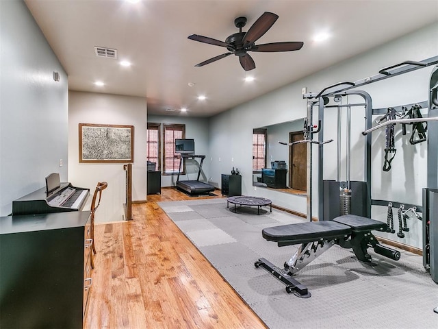 exercise room with ceiling fan and light hardwood / wood-style flooring