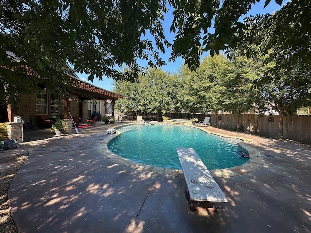 view of pool featuring a diving board and a patio area