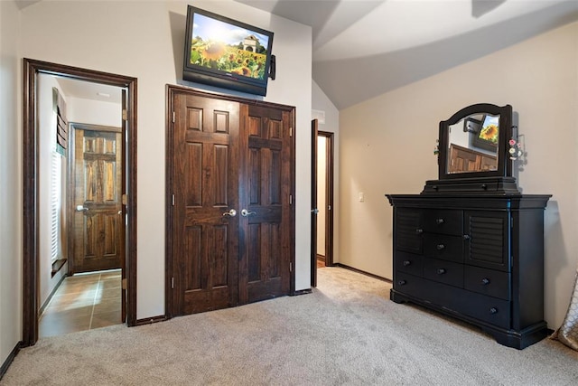 bedroom with light colored carpet and lofted ceiling