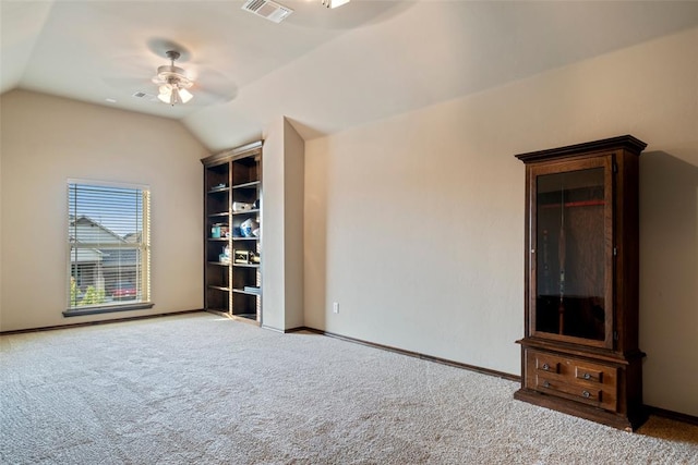 empty room featuring ceiling fan, light colored carpet, and lofted ceiling