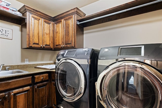 washroom with washer and dryer, cabinets, and sink