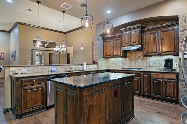 kitchen featuring kitchen peninsula, a center island, stainless steel appliances, and hardwood / wood-style flooring