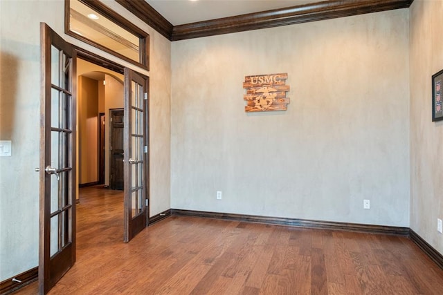 spare room with french doors, hardwood / wood-style flooring, and crown molding