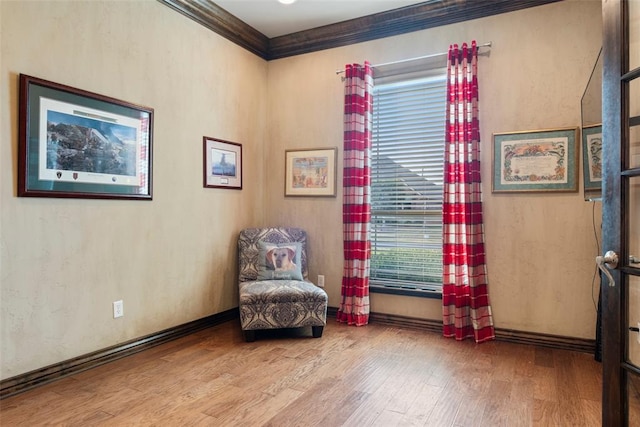 sitting room featuring ornamental molding and hardwood / wood-style flooring