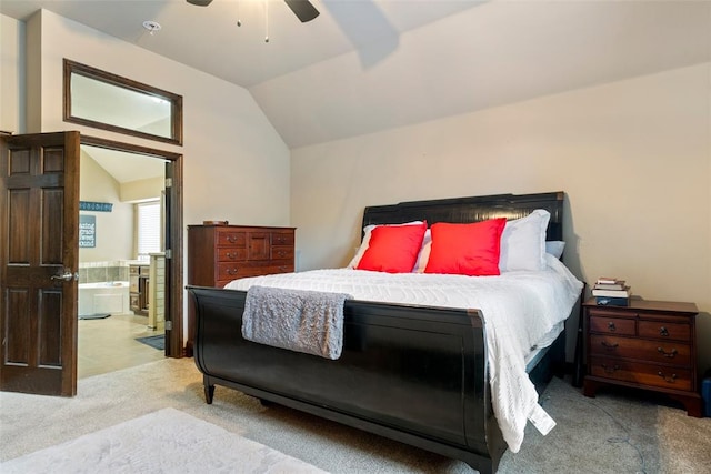 bedroom with ceiling fan, light colored carpet, ensuite bathroom, and vaulted ceiling