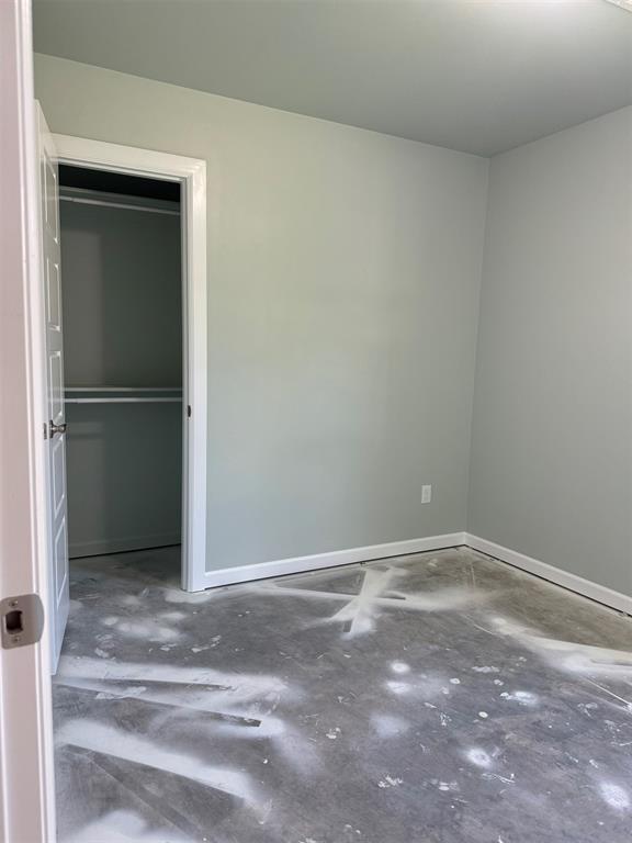 unfurnished bedroom featuring concrete flooring