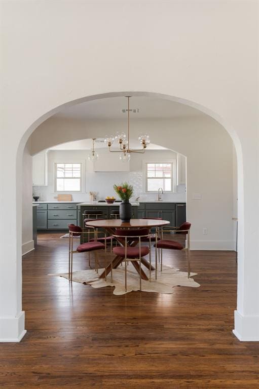 dining area featuring wine cooler, a wealth of natural light, dark hardwood / wood-style floors, and a notable chandelier