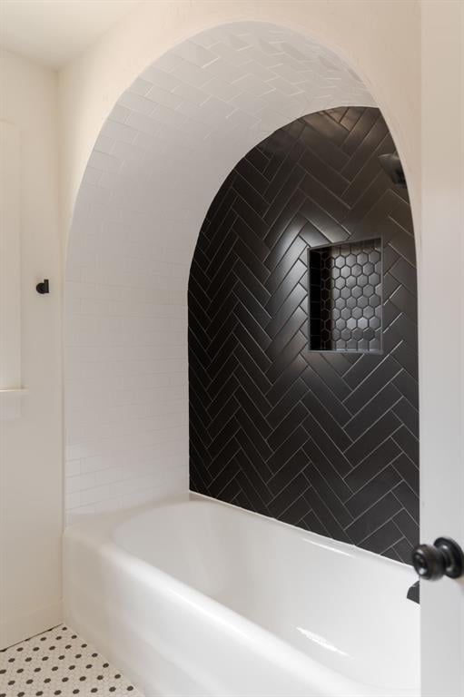 bathroom with tile patterned flooring and a tub