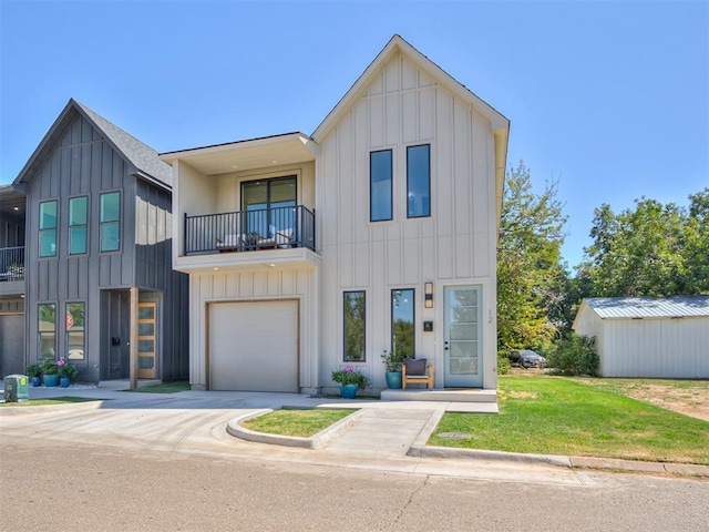 view of front facade with a garage, a balcony, and a front yard