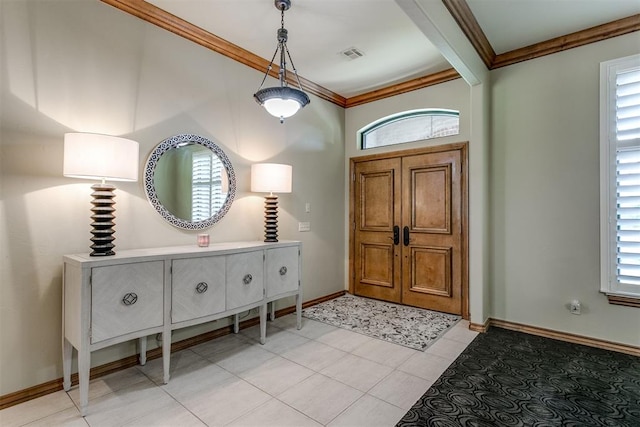 foyer entrance featuring a healthy amount of sunlight, light tile patterned floors, and crown molding