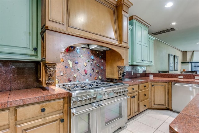 kitchen with backsplash, light tile patterned floors, and stainless steel appliances