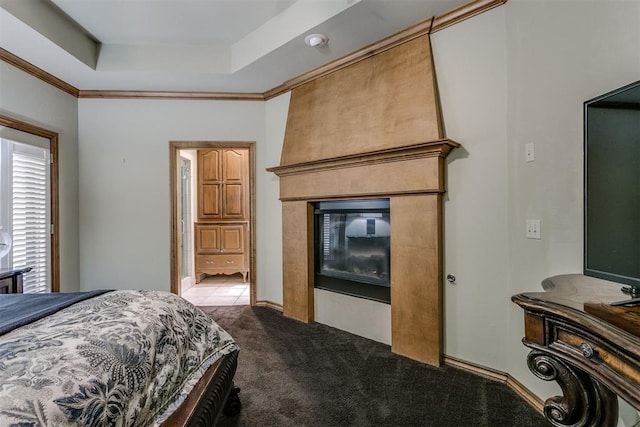 carpeted bedroom with a raised ceiling, crown molding, and a large fireplace