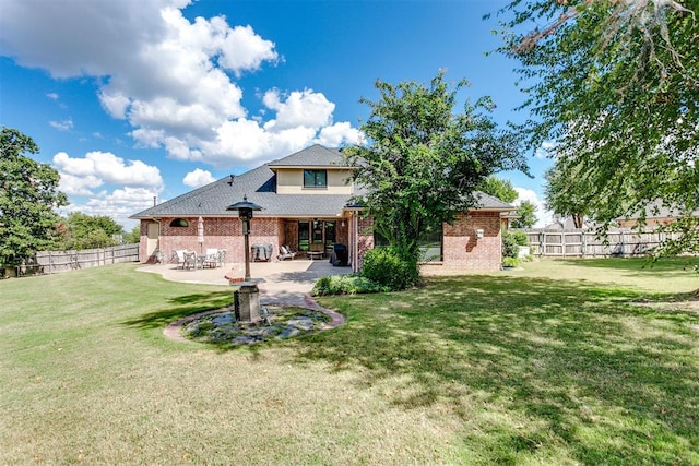 rear view of house with a yard and a patio