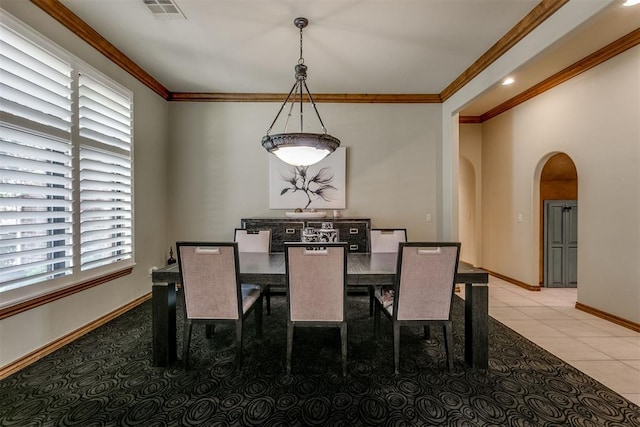 tiled dining room featuring plenty of natural light and ornamental molding