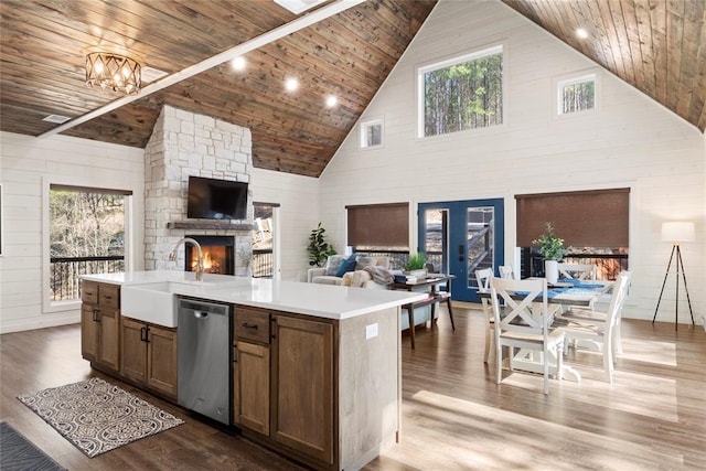 kitchen featuring dishwasher, a center island with sink, high vaulted ceiling, and wood ceiling