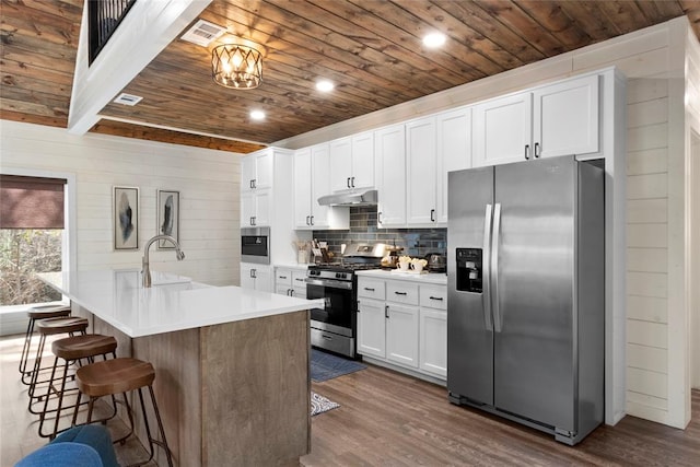 kitchen featuring stainless steel appliances, white cabinetry, a kitchen island with sink, and sink