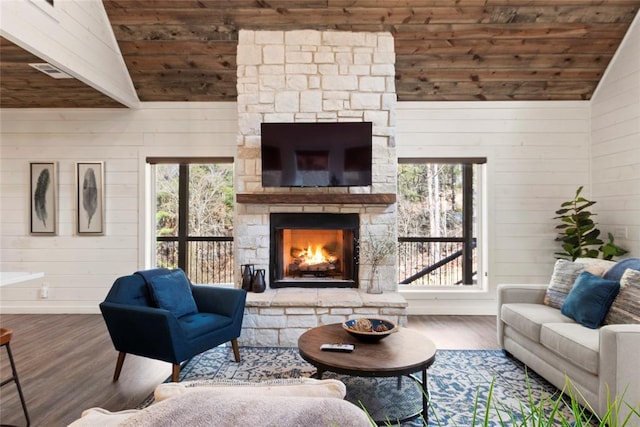 living room with lofted ceiling, wooden ceiling, wooden walls, hardwood / wood-style flooring, and a fireplace