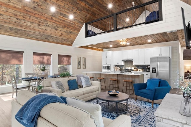 living room featuring wood ceiling, light wood-type flooring, and high vaulted ceiling