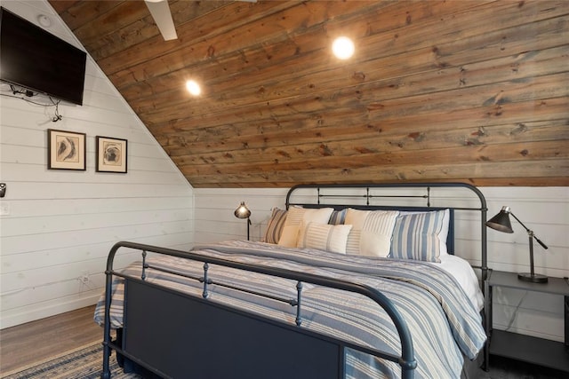 bedroom with dark hardwood / wood-style floors, lofted ceiling, and wood walls