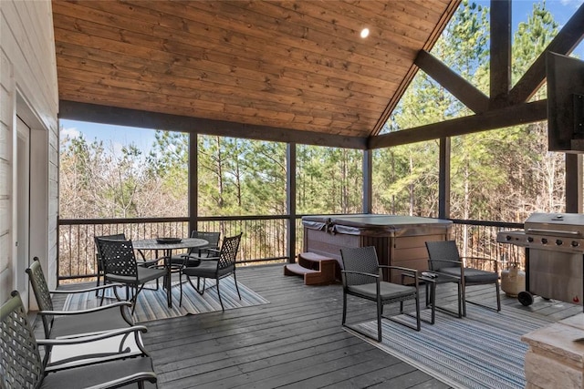 sunroom featuring vaulted ceiling, a healthy amount of sunlight, and a hot tub