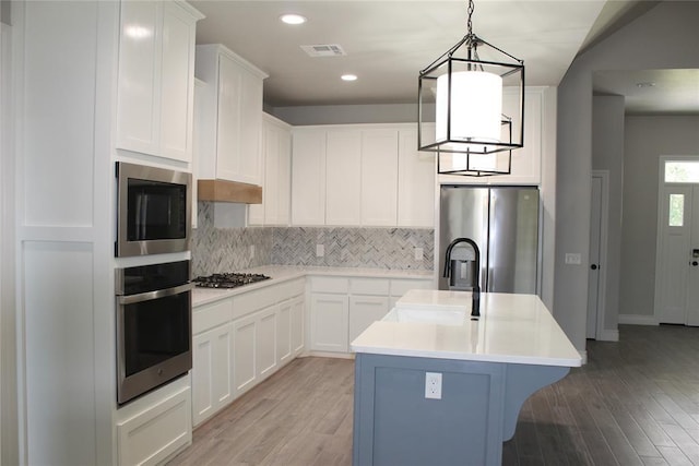 41208 Hazel Dell Rd, Shawnee, OK 74804 - kitchen with stainless steel appliances, decorative backsplash, light wood-style flooring, light countertops, and recessed lighting