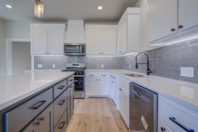 kitchen featuring stainless steel appliances, white cabinetry, and sink