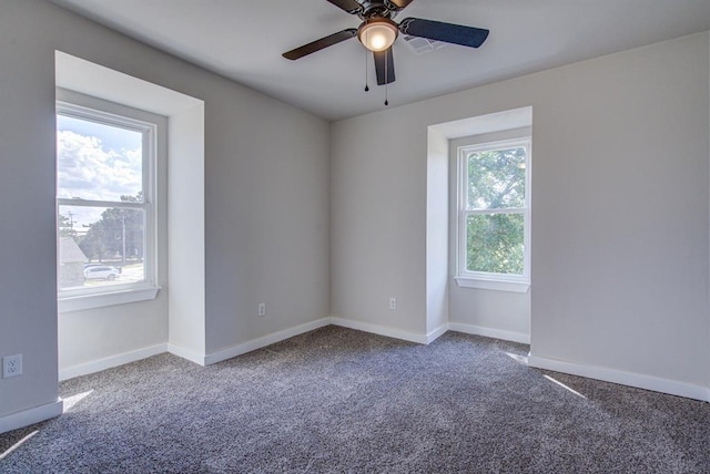 carpeted spare room with a wealth of natural light and ceiling fan