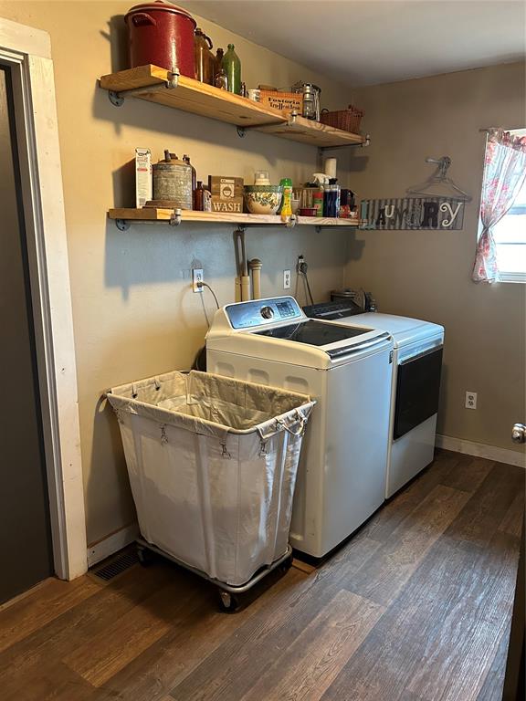 clothes washing area featuring independent washer and dryer, dark wood-type flooring, and sink