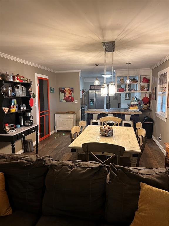 dining area with crown molding and dark hardwood / wood-style flooring