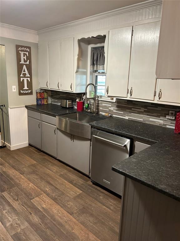 kitchen featuring dishwasher, white cabinets, sink, ornamental molding, and dark hardwood / wood-style flooring