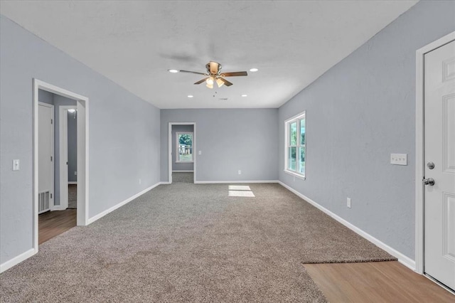 empty room featuring ceiling fan, carpet, and a healthy amount of sunlight