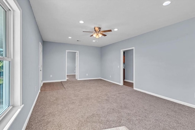 empty room featuring ceiling fan, a healthy amount of sunlight, and carpet floors