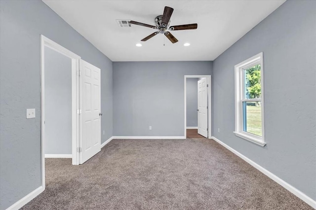 unfurnished bedroom featuring dark colored carpet and ceiling fan