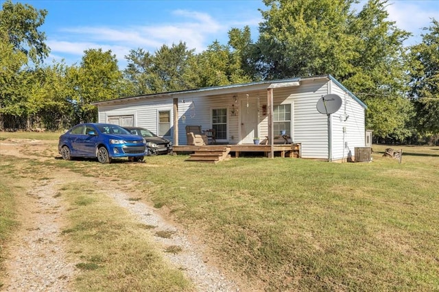 back of house featuring central AC unit and a yard