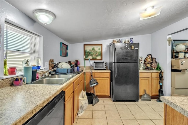 kitchen with sink, stainless steel dishwasher, vaulted ceiling, black refrigerator, and light tile patterned floors